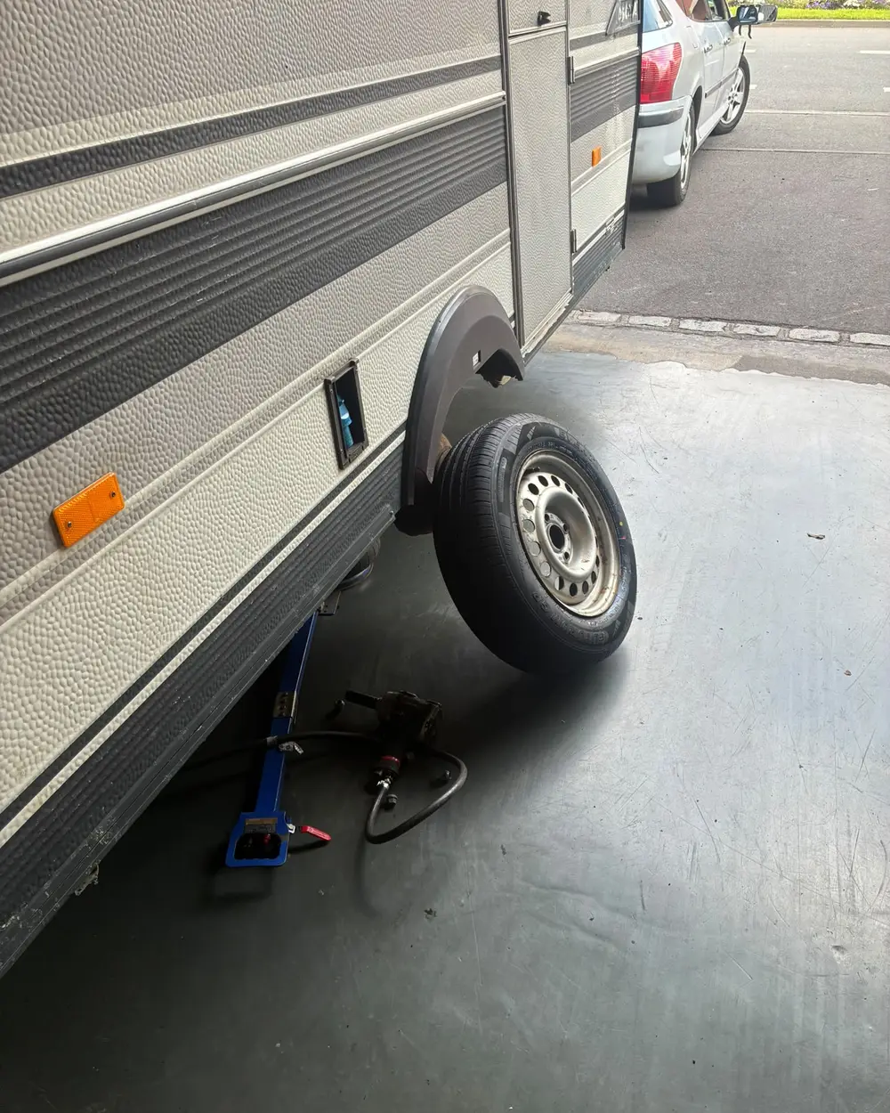 Réparation de pneu crevé sur place à Calais : véhicule sur cric et changement de roue en intervention mobile.